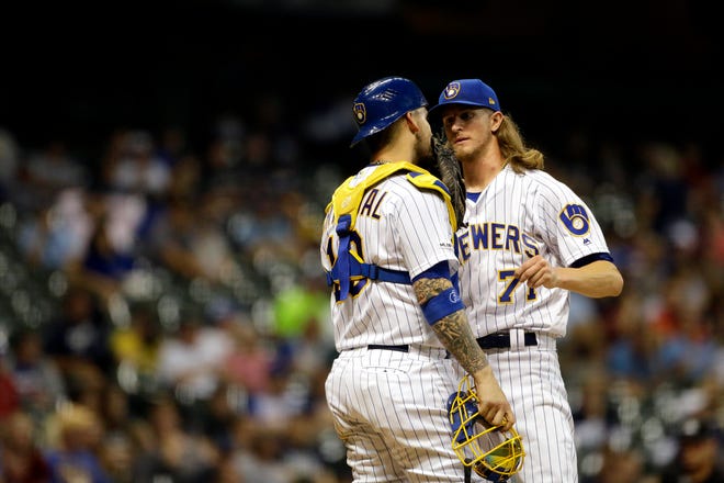 Brewers reliever Josh Hader talks with catcher Yasmani Grandal during the ninth inning Friday night.