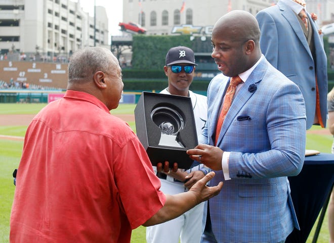 Former Detroit Tigers player Willie Horton (left) presents another former Tigers, Craig Monroe, with the Detroit Tigers Willie Horton African American Legacy Award and Tigers first base coach Ramon Santiago (center) watches before Sunday's game against the Kansas City Royals. Detroit, Aug. 11, 2019.