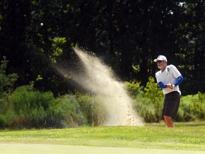 Bob Plants blasts out of the greenside bunker on the 17th hole during the Zanesville District Golf Association Senior Amateur on Saturday at Vista Golf Course. Plants holed the shot for a birdie. 
