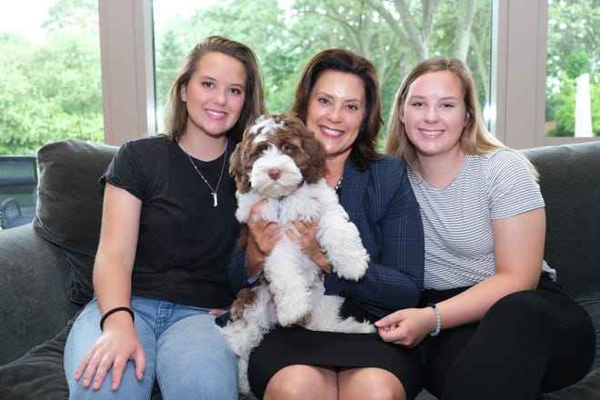 Michigan Governor Gretchen Whitmer and her daughters Sydney and Sherry play with their new Labradoodle puppy, Kevin.