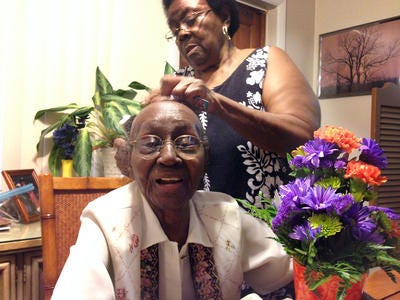 Regina Smith's daughter, Snoozie, styling her mother's hair before her 100th birthday celebration.
