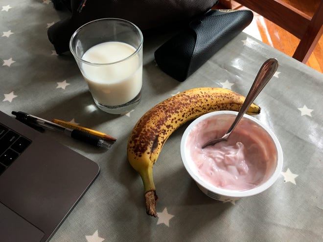 This July 31, 2019 photo shows a yogurt and a banana with a glass of milk on a table in the Brooklyn borough of New York. Even kids who don't want a full breakfast on school mornings may have room for a quick cup of yogurt and a piece of fresh fruit. (Melissa Rayworth via AP)