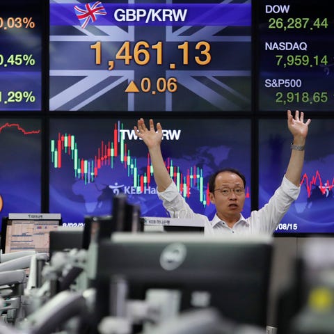 A currency trader gestures at the foreign...