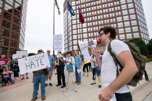 Duncan Tarr, with the group No Detention Centers in Michigan, uses a bullhorn to help lead a protest outside a Prudential financial services branch office building on West Big Beaver, in Troy, August 13, 2019. The protestors called on Prudential to divest from GEO Group Inc., a major private prison who is producing an immigrant detention center in Baldwin, Michigan.