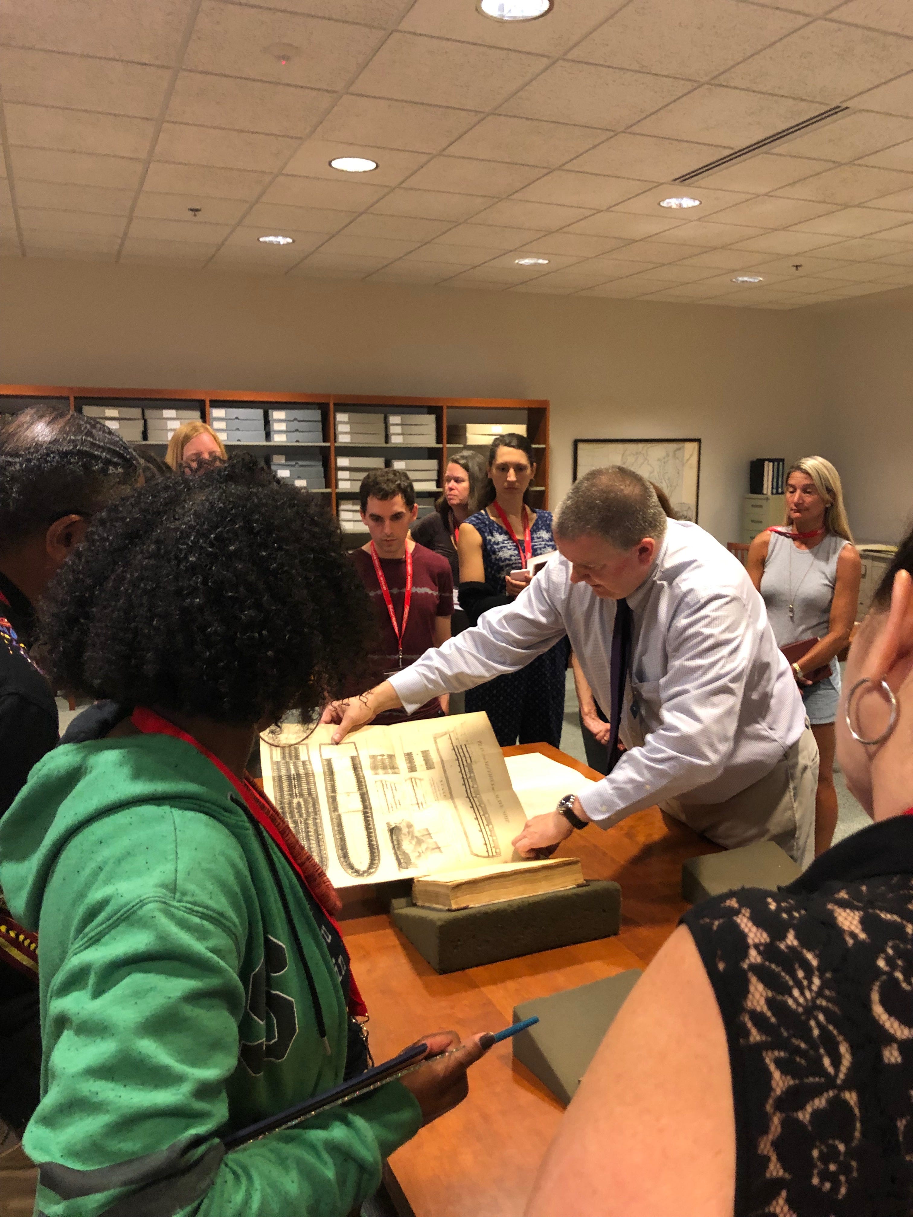 Colonial Williamsburg librarian Doug Mayo shows teachers an 18th-century document of the inside of a slave ship.