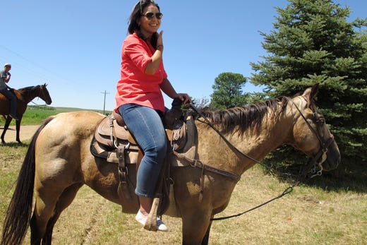 U.S. Rep.and presidential hopeful Tulsi Gabbard, of Hawaii, rides a horse into a solar farm on the Standing Rock Indian Reservation in Cannon Ball, N.D., for the grand opening of the project on July 26, 2019.