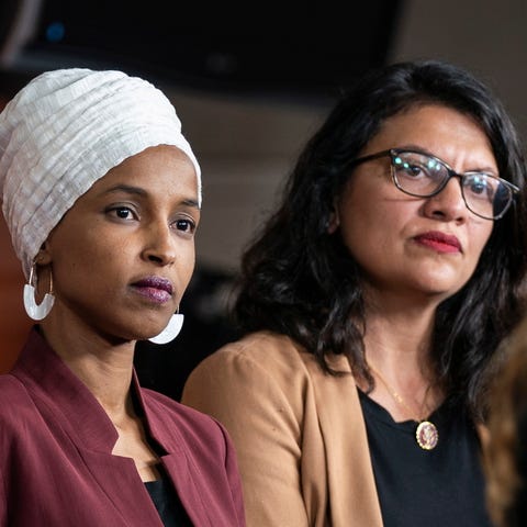 Democratic Representatives Ilhan Omar (L) and...