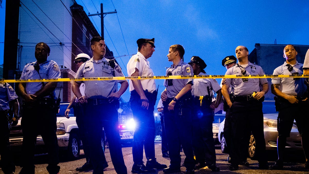 Officers gather for crowd control as they investigate a shooting in Philadelphia on Aug. 14, 2019.
