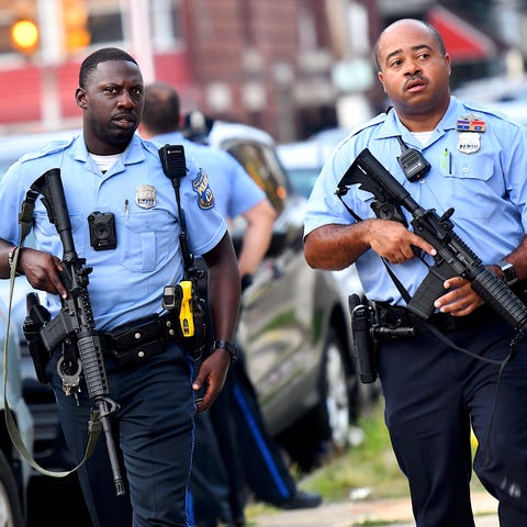 Police officers carrying assault rifles respond to
