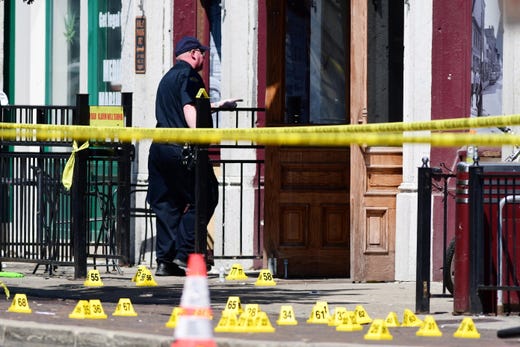 Evidence markers of shell casings line the street at the scene of a shooting in the Oregon District of Dayton, Ohio, Aug. 4, 2019. According to preliminary reports from police, nine people were killed and 27 others wounded and are being treated in local hospitals. The shooter was killed by police.
