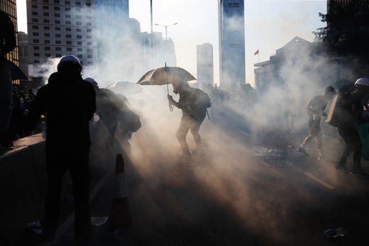 Anti-extradition protesters react after police fired tear gas at them in Hong Kong, China, Aug. 5, 2019. Hong Kong is in the midst of a day of citywide strike following a ninth consecutive weekend of multiple anti-extradition rallies and intense clashes between demonstrators and police over the now suspended extradition bill to China.