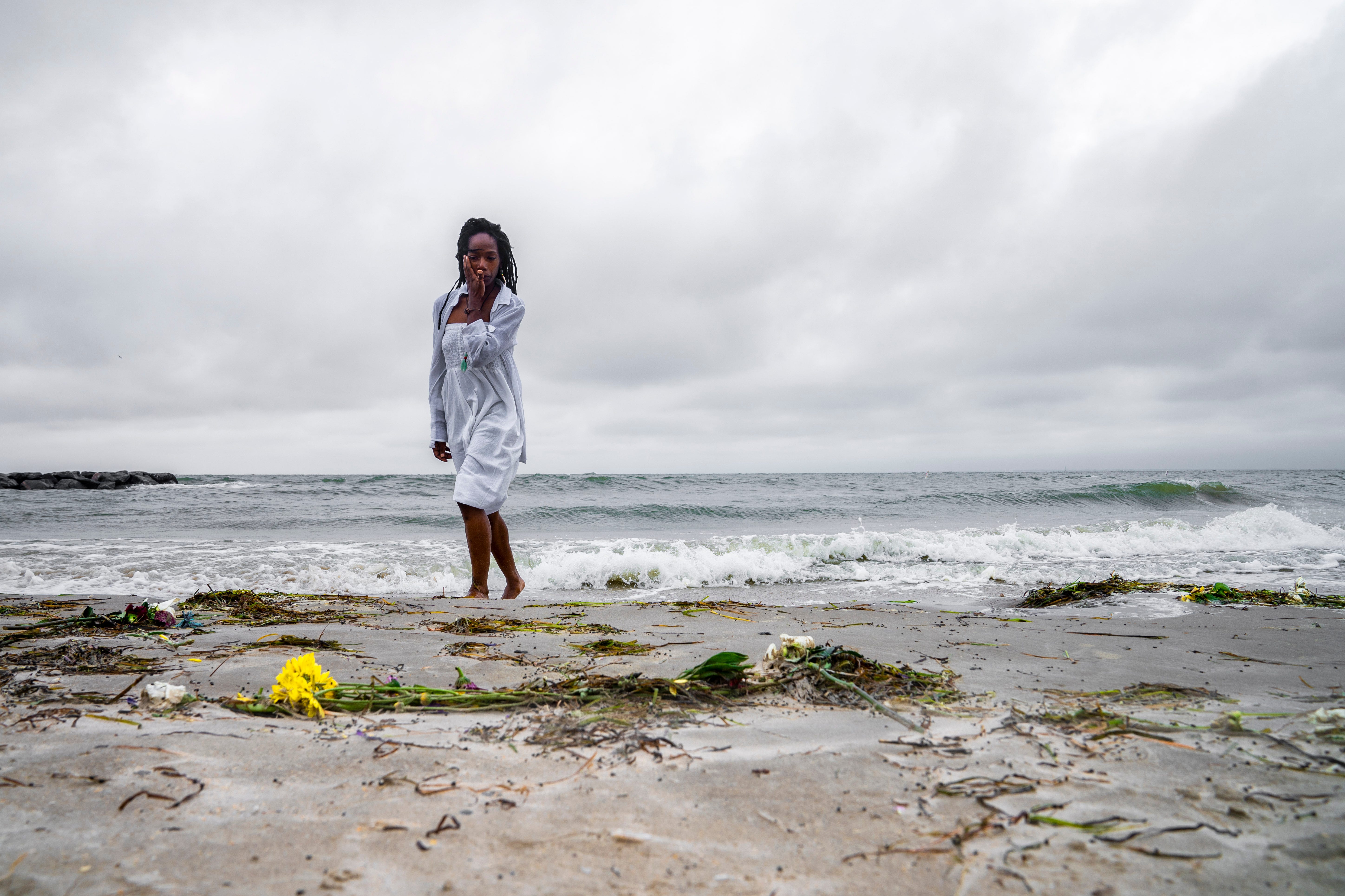 Samantha Lewis wipes away tears after reflecting on the "Day of Remembrance," which honors Africans who were captured as slaves and died during the Middle Passage. The remembrance was in Hampton, Virginia.