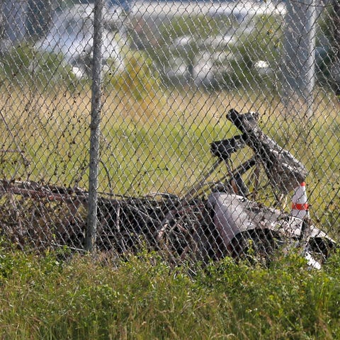 The charred wreckage of a private plane is seen...