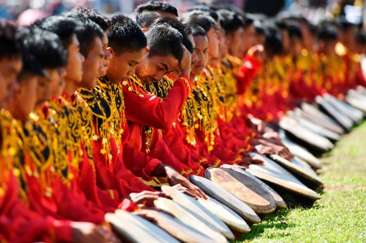 Performers take part in the Rapa'i Geleng dance, using a traditional tambourine, to celebrate Indonesia's 74th Independence Day in Blang Pidie, Aceh province on Aug. 17, 2019.