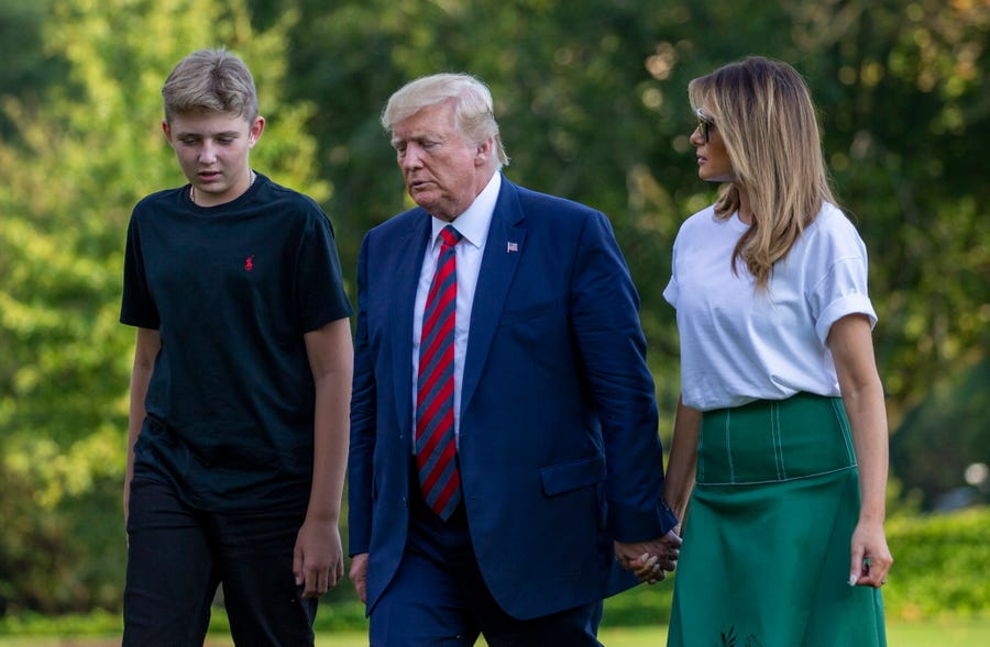 President Donald Trump, flanked by first lady Melania Trump and son Barron, 13,  return to the White House following a stay in Bedminster, N.J.