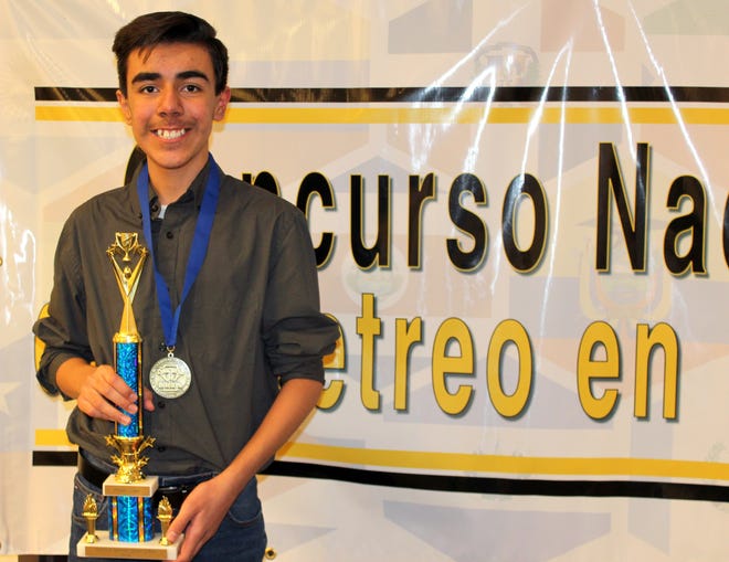 Maximiliano Hultsch Martinez, 14, holds his national championship trophy from the National Spanish Spelling Bee.