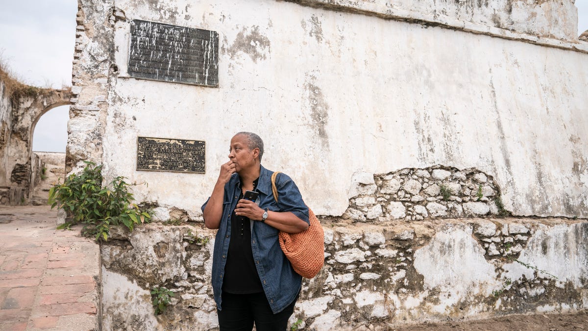Wanda Tucker sits outside of the Fortaleza de Massangano on Saturday, Aug. 3, 2019 in Angola. The fort would have been the first place Africans were captured, branded and baptized before walking or being transferred by canoe down the Kwanza river to Angola for transport via the Transatlantic slave trade. 
