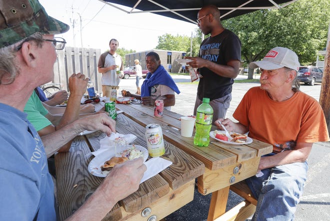 St. John's shelter residents socialize during a cookout Aug. 15, 2019, at the Micah Center in Green Bay, Wis.