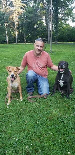 White Lake resident Scott Lorms with his two emotional support animals, dogs named Curiz (left) and Riley (right). Lorms is suing Brighton-based property manager T&R Properties and Zahler Management for denying him the right to apply to rent an apartment in Pinckney because they do not allow dogs but Lorms has a notification from his doctor for them.