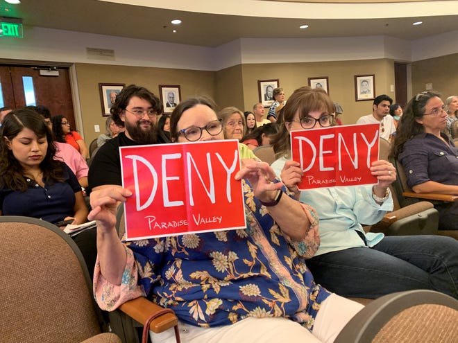 Two opponents of the proposed Paradise Valley development hold signs as a Riverside County Planning Commission member said he would vote in favor of continuing the consultation off-calendar instead of denying the development on Aug, 21, 2019.