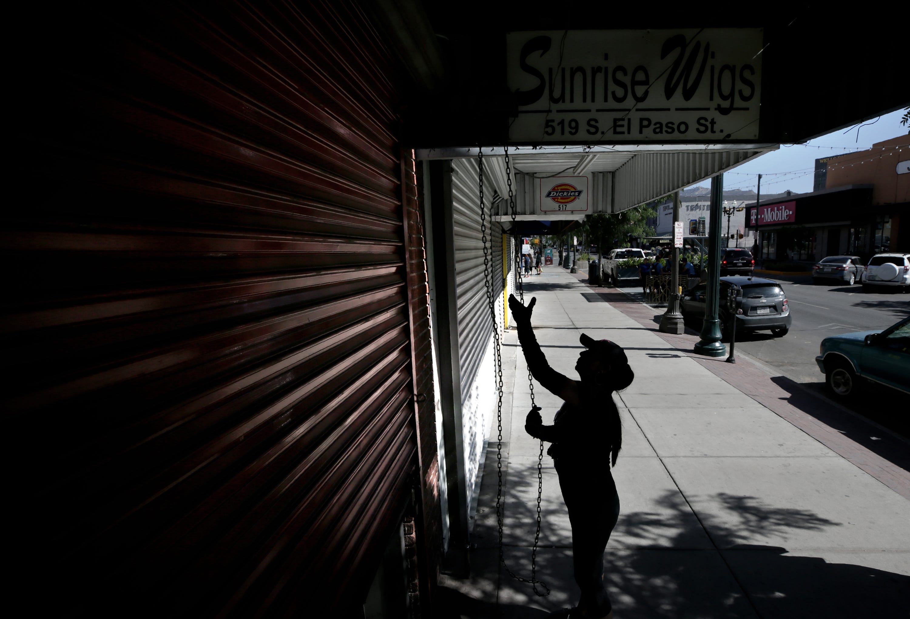 EL PASO, Texas – Elsa Arrambide, co-owner of Sunrise Wigs in downtown El Paso, opens her shop Sunday morning on a popular shopping street for border crossers. Arrambide says business is way down as long lines have become the norm on the Paso del Norte International Bridge only a few block south.