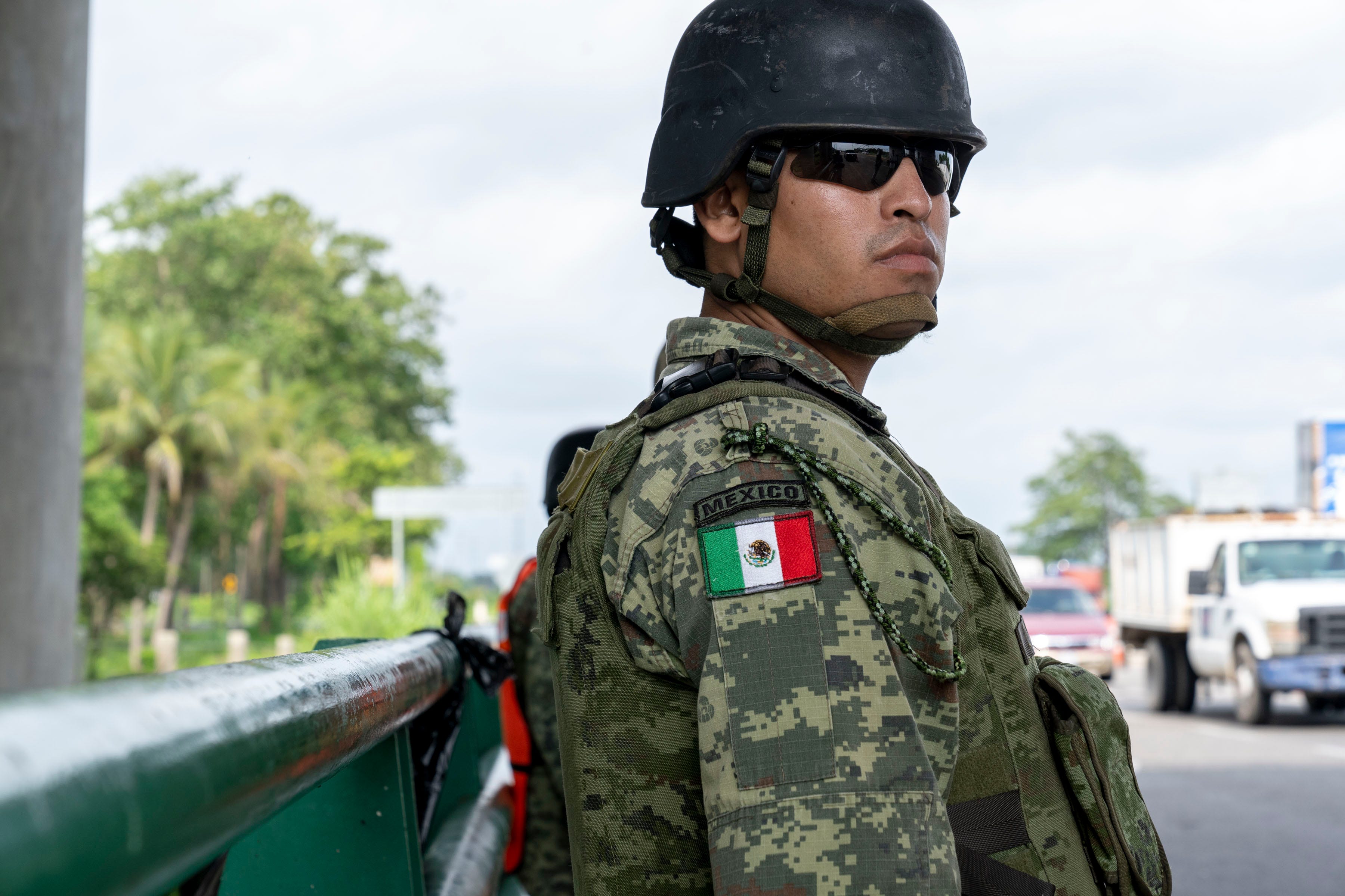 TAPACHULA, Mexico – A member of Mexico’s National Guard stands watch as a Mexican immigration officer boards a bus headed north on the Pacific Coast Highway near Tapachula. In June, Mexico’s President Andrés Manuel López Obrador, under pressure from the U.S., sent National Guard troops to help immigration authorities block migrants from Central America from reaching the U.S.