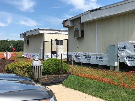The Wall Township school board stopped repair work on two damaged and ant-filled trailers at Central Elementary School. Flexible fencing and caution tape now surrounds the buildings.