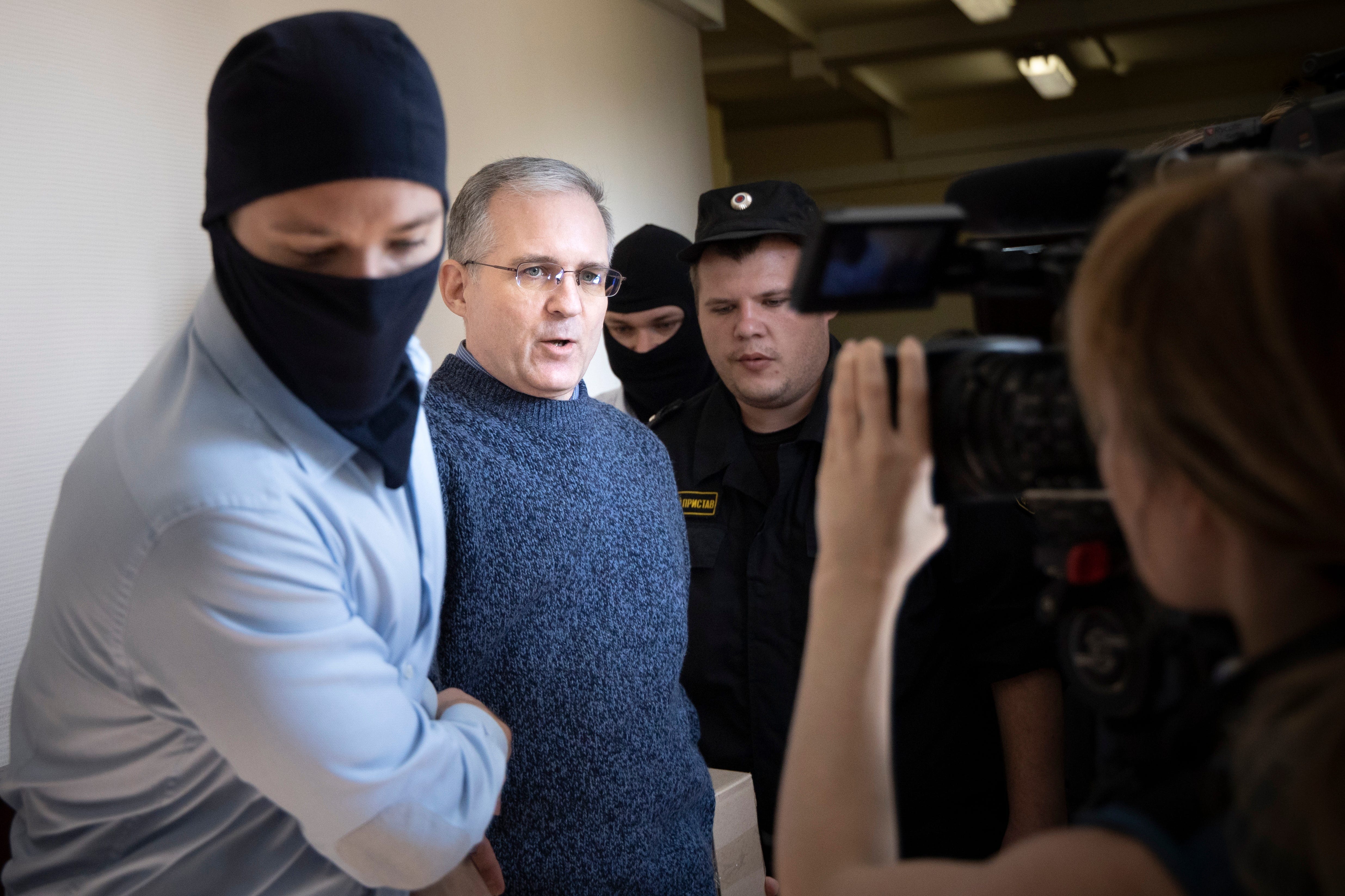 Paul Whelan, second from left, was arrested and accused of spying in Moscow. He speaks to a journalist as he escorted by Russian Federal Security Service officers into a courtroom in Moscow, Russia, Friday, Aug. 23, 2019.