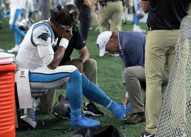 Panthers quarterback Cam Newton receives attention on the sideline after an injury in the first half of Thursday's preseason game.
