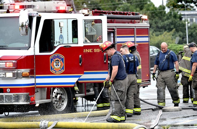 Fire personnel gather equipment outside the Yorktown Mall where several business were damaged after an early morning fire Friday, Aug. 23, 2019. The mall is located in the 100 block of North Duke Street. Bill Kalina photo