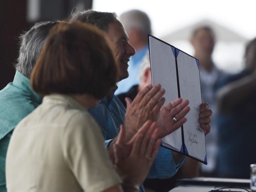Texas Gov. Greg Abbott holds the signed House Bill 6 at the Fulton fishing pier groundbreaking, Saturday, Aug. 24, 2019, in Fulton. The bills will provide emergency management, response and recovery in Texas.