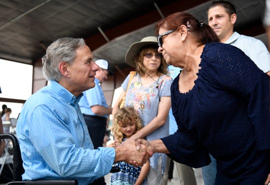 Gov. Greg Abbott, left, shakes hands with Nancy Arispe, Saturday, Aug. 24, 2019, in Fulton. Arispe says she lost her businesses, Captain Benny's and Nancy's Beauty, during Hurricane Harvey but can receive assistance because of House and Senate Bill 6.