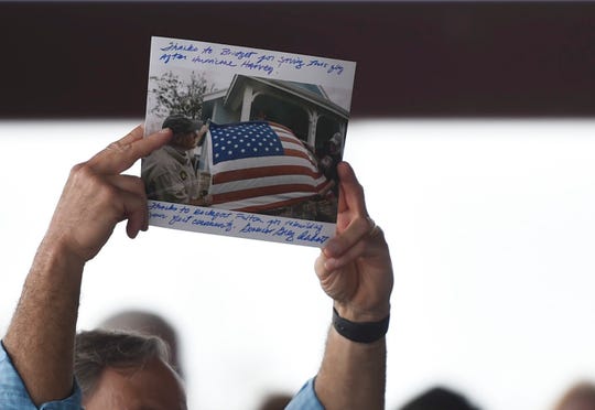 Texas Gov. Greg Abbott holds a photo of an American flag he saw when visiting Rockport after Hurricane Harvey, Saturday, Aug. 24, 2019, in Fulton. Abbott gave the photo to Fulton Mayor Jimmy Kendrick.