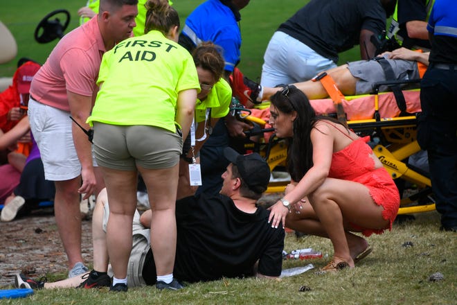 Spectators are tended to after a lightning strike on the course which left several injured during a weather delay Saturday in the third round of the Tour Championship golf tournament in Atlanta.