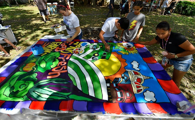 Volunteers paint a mural depicting the York Fresh Food Farm during the Yorkfest Fine Arts Festival, Sunday, August 25, 2019. Hundreds of visitors contributed to the mural during the two-day festival. The mural will be hung at the bus terminal on King Street after completion.John A. Pavoncello photo