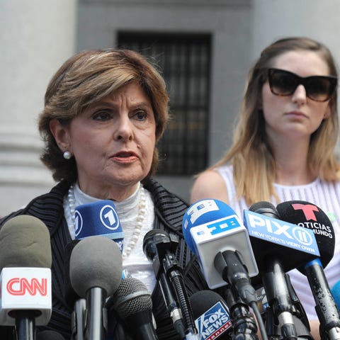 Attorney Gloria Allred, center, flanked by two cli