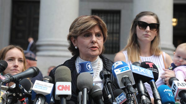 Attorney Gloria Allred, center, flanked by two cli