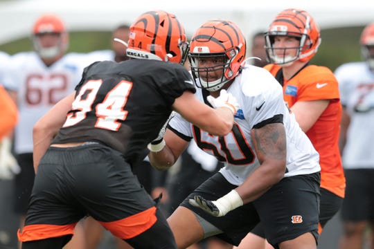 Cincinnati Bengals offensive guard Michael Jordan (60) blocks Cincinnati Bengals defensive end Sam Hubbard (94) as Cincinnati Bengals quarterback Andy Dalton (14) takes the snap during Cincinnati Bengals training camp practice, Tuesday, Aug. 13, 2019, at the practice fields next to Paul Brown Stadium in Cincinnati. 