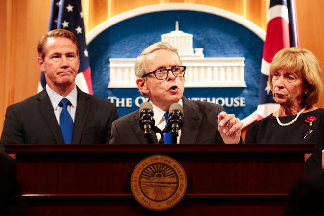 Ohio Gov. Mike DeWine delivers a statement with Lt. Gov. Jon Husted, left, and First Lady Fran DeWine, right, following the Dayton Mass Shooting on Tuesday, Aug.  6, 2019 at the Ohio Statehouse in Columbus, Ohio.  Facing pressure to take action after the latest mass shooting in the U.S., DeWine urged the GOP-led state Legislature Tuesday to pass laws requiring background checks for nearly all gun sales and allowing courts to restrict firearms access for people perceived as threats. (Joshua A. Bickel /The Columbus Dispatch via AP)