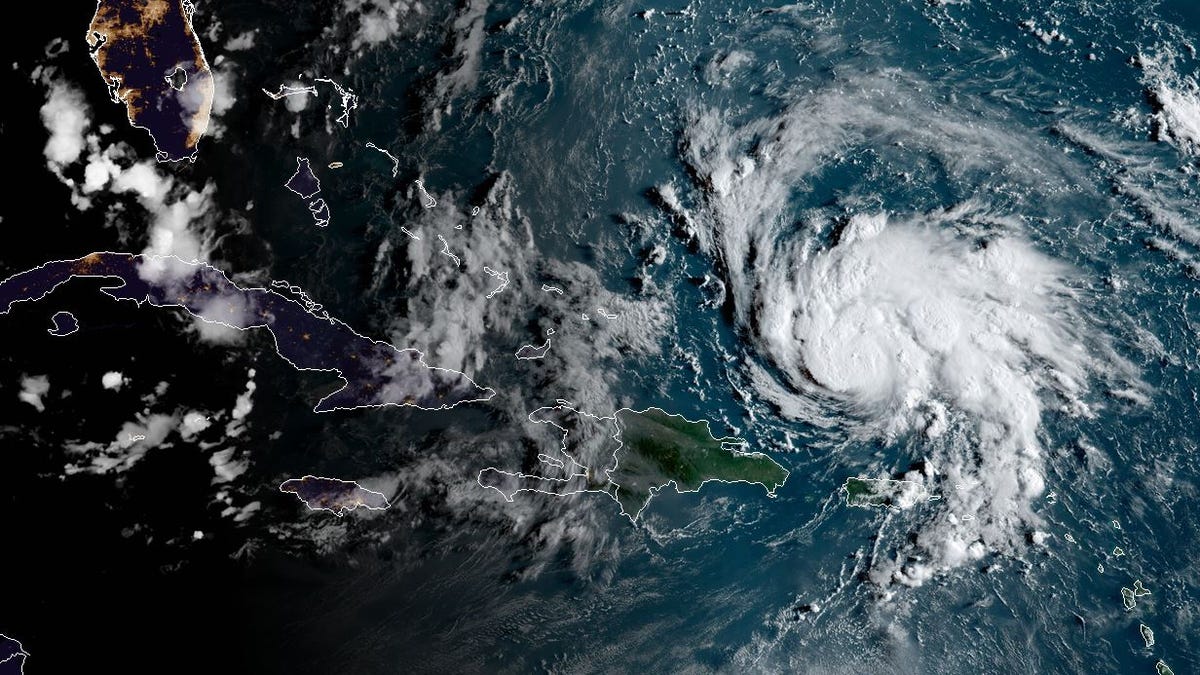 This satellite image obtained from NOAA/RAMMB, shows Hurricane Dorian (R) as it  passes Puerto Rico at 11:30 central time on August 29, 2019. The National Hurricane Center (NHC) in Miami said the hurricane watch and tropical storm warning for the island had been lifted, and that "Dorian continues to move away from Puerto Rico and the Virgin Islands."