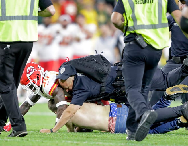 A fan is tackled after running onto the field during the Green Bay Packers preseason football game against the Kansas City Chiefs Thursday at Lambeau Field in Green Bay.