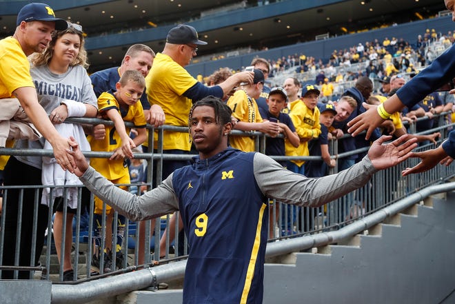 Donovan Peoples-Jones high-fives fans as he walks down the tunnel before the opener against Middle Tennessee State.