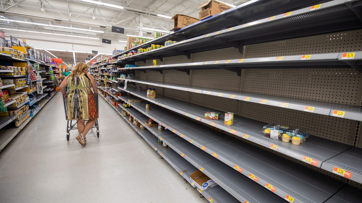 A person walks past an empty shelf at a Walmart Supercenter on Merritt Island, Florida, August 30, 2019. Floridians are stocking up on supplies in preparation for Hurricane Dorian, which is expected to make landfall late on 04 September as a strong Category 4 hurricane.