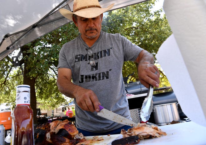 Johnny De La Garza of the Smokin' and Jokin' cooking team cuts up barbecued chicken Saturday during the 38th Annual Rentech Chili Superbowl & Cookoff. Held at Buffalo Gap's Old Settlers Reunion Grounds. The annual cookoff benefits the Ben Richey Boys Ranch.