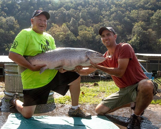 Fishing guide Bill Babler, left, holds his 40-pound, 6-ounce brown trout he caught last September at Lake Taneycomo. It remains the Missouri record brown trout.