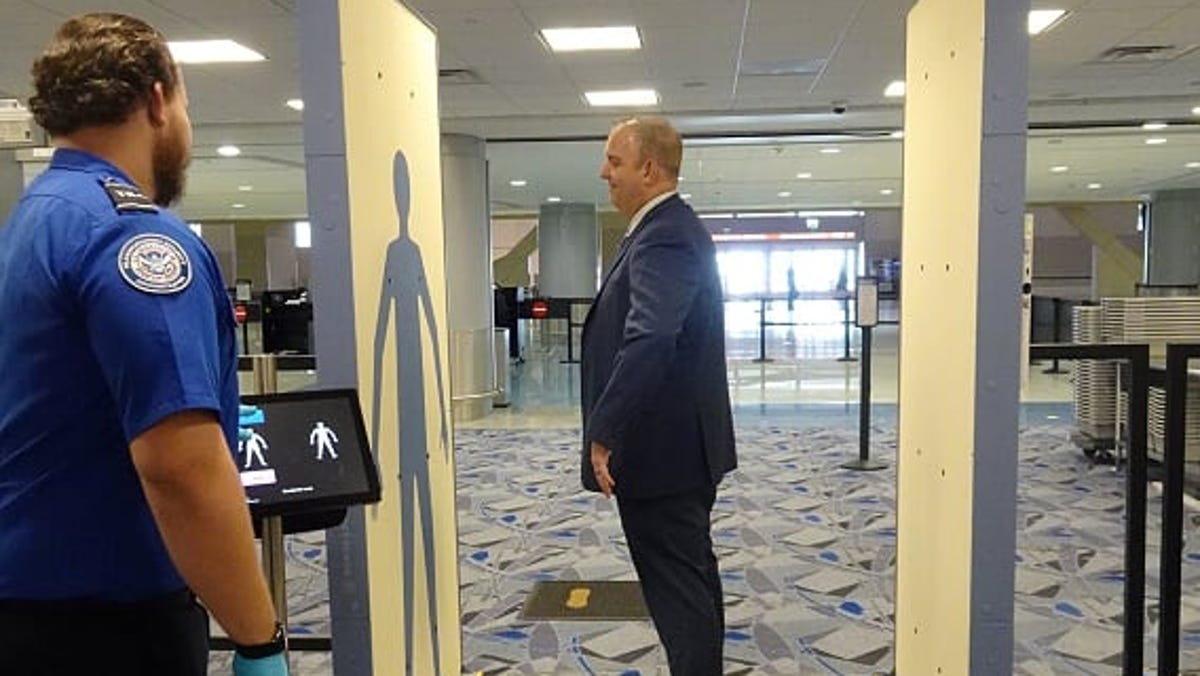 Greg McIntyre, the TSA's transportation security manager in Las Vegas, demonstrates a new body scanner, an an enhanced advanced imaging technology machine,  being tested at a new checkpoint in the basement of the airport.
