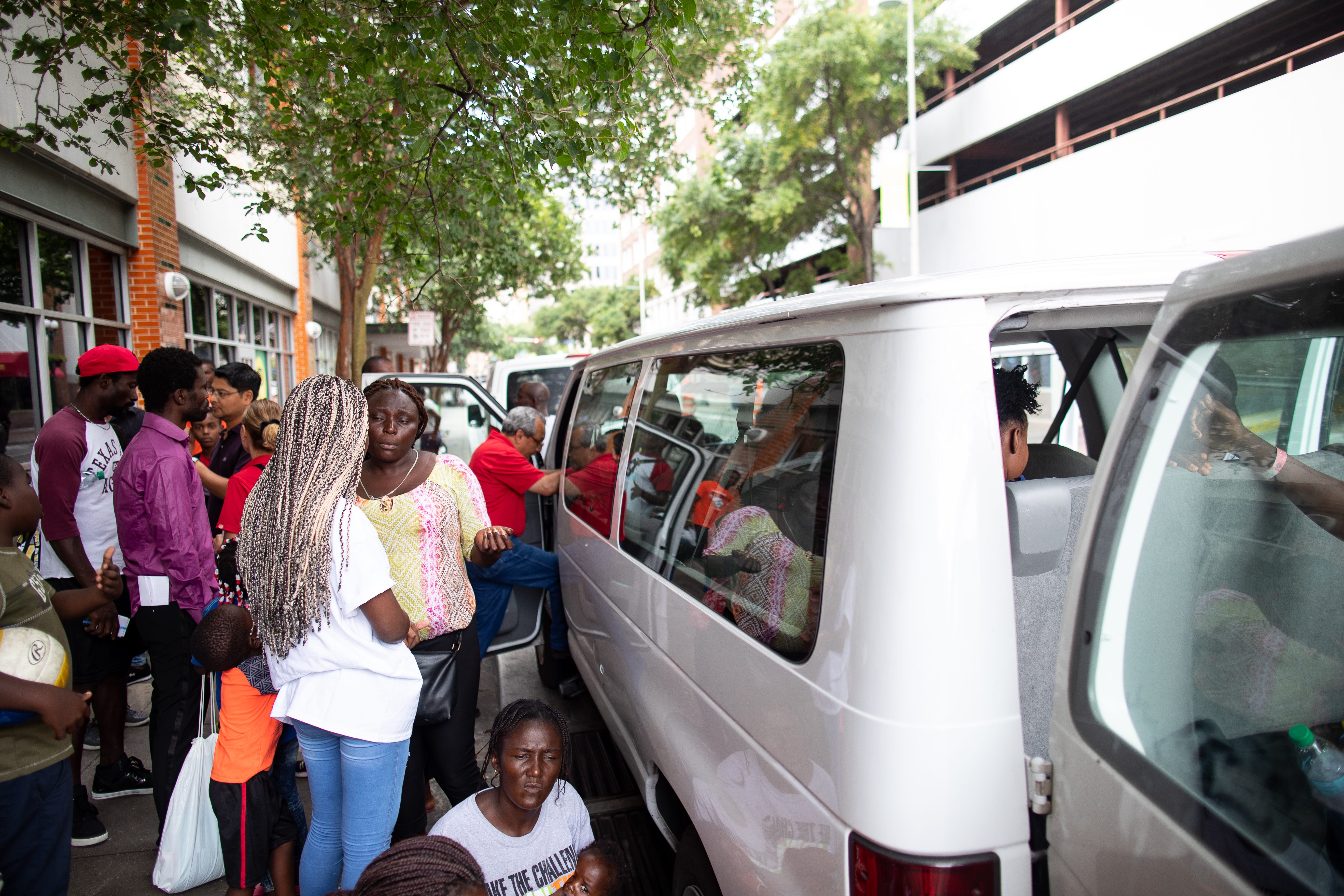 SAN ANTONIO, Texas – A group of migrants board a city van bound for the San Antonio airport outside the San Antonio Migrant Resource Center on June 27, 2019.