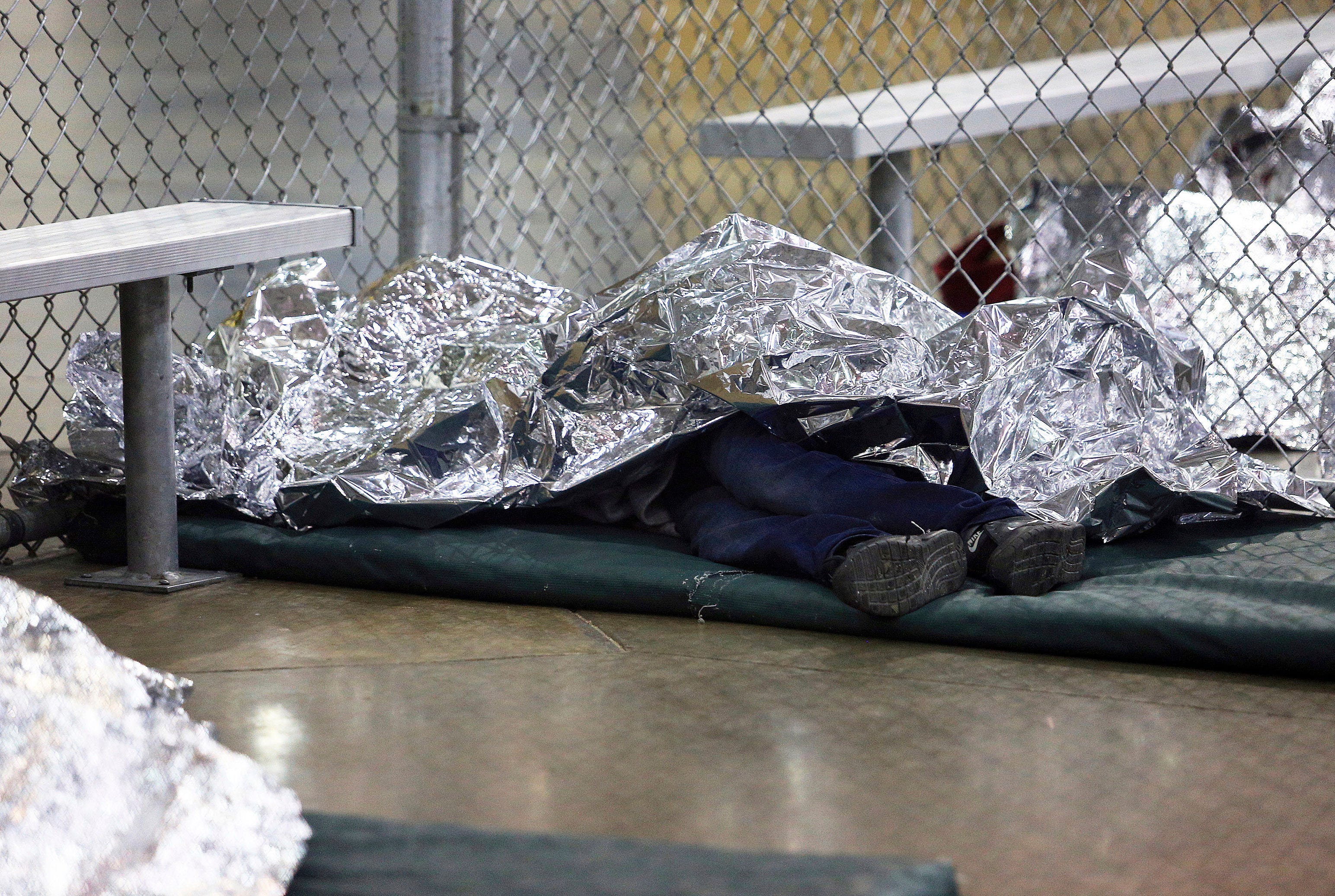 MCALLEN, TX – A detained immigrant sleeps under mylar blankets inside a holding cell at the Border Patrol's processing center in McAllen, Texas on Aug. 12, 2019.