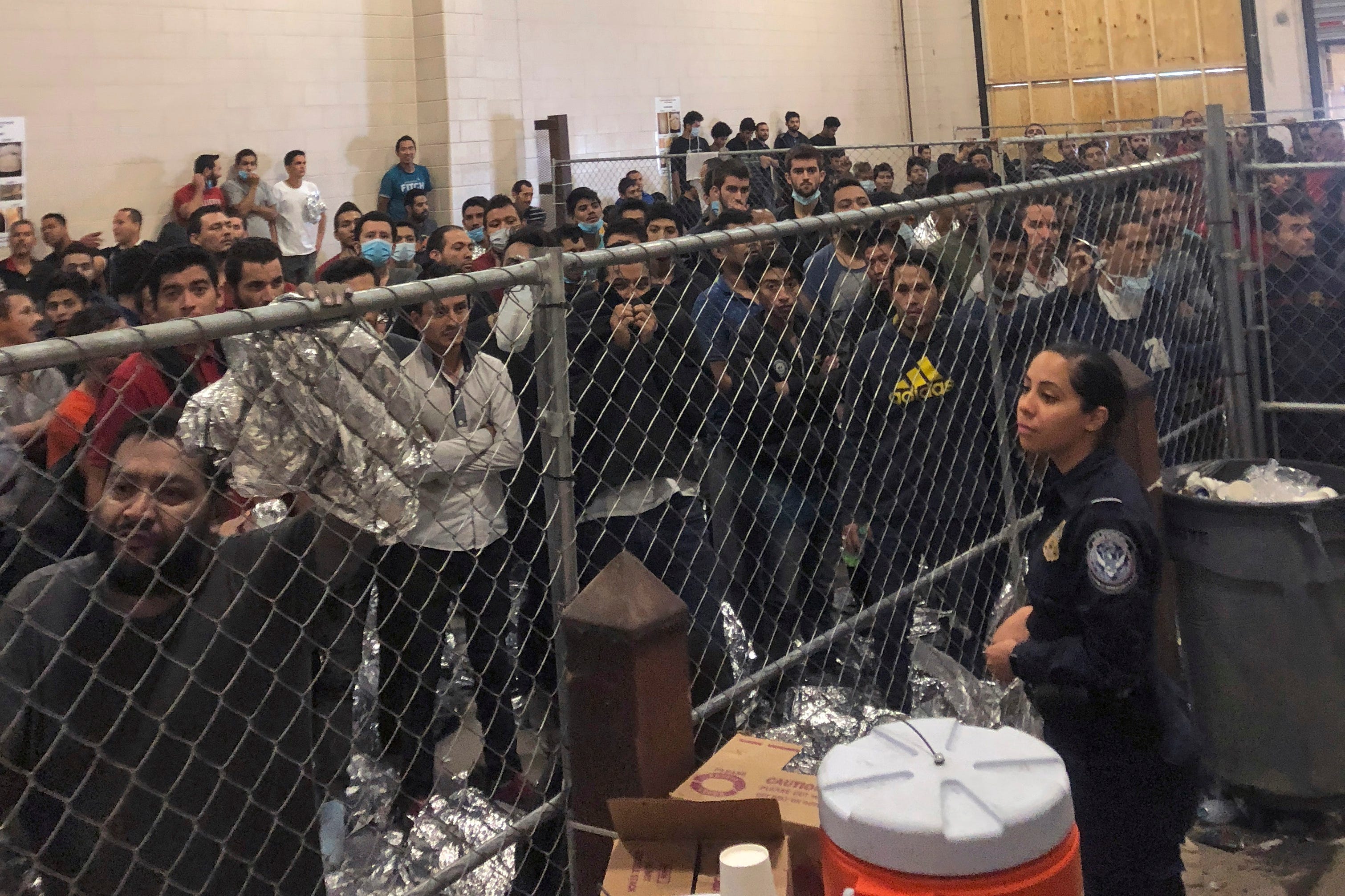 MCALLEN, TX – Men stand in a U.S. Immigration and Border Enforcement detention center in McAllen, Texas, during a visit by Vice President Mike Pence on July 12, 2019.