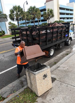 Terence Powell puts a lid back on a North Ocean Boulevard garbage can in Myrtle Beach, South Carolina Friday, Sept. 6, 2019. Powell said the city took them off before Hurricane Dorian came so they would not blow off.